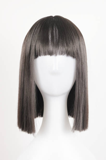 istock Natural looking black wig on white mannequin head. Medium length straight hair with bangs on the metal wig holder isolated on white background, front view 1816330846
