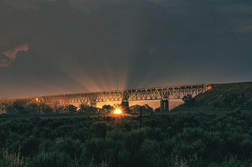 A picturesque scene of a large bridge illuminated by the warm, golden light of the setting sun
