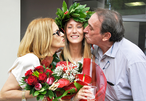 Young woman on graduation day with her parents