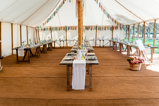 English wedding reception in a white marquee with flowers and table decorations