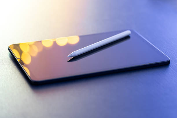Designer workspace with digital tablet and stylus pen on the table close-up.