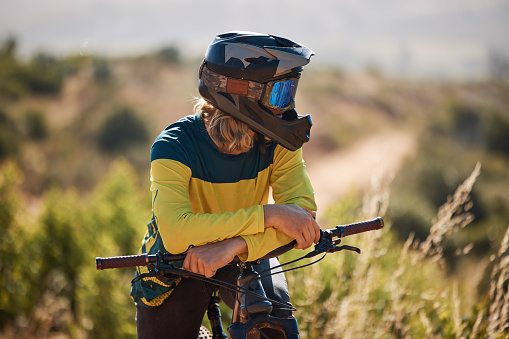 Bike, athlete and sport outdoor, cycling and break with helmet for safety and fitness with mountain bike through woods. Biker with bicycle, nature and extreme sports, relax and rest after exercise.