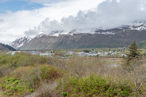 Valdez, Alaska, USA with snow and cloud covered mountains behind