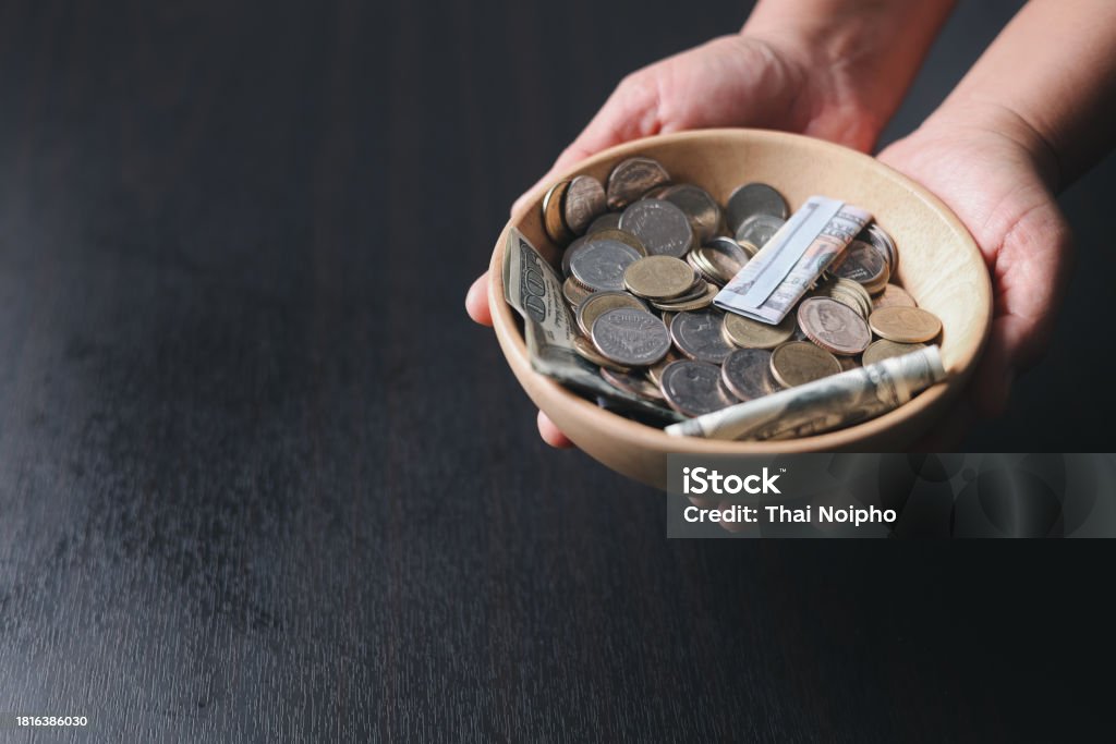 One tenth or tithe is basis on which Bible teaches us to give one tenth of first fruit to God. coins with Holy Bible. Biblical concept of Christian offering, generosity, and giving tithes in church. Church Stock Photo