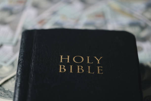 istock One tenth or tithe is basis on which Bible teaches us to give one tenth of first fruit to God. coins with Holy Bible. Biblical concept of Christian offering, generosity, and giving tithes in church. 1816386135