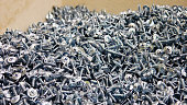 A big pile of beautiful silver screws close-up
