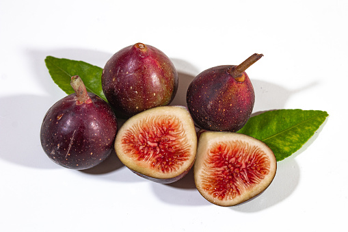 Figs are served dark purple, with a beautiful bright red filling, decorated with bright green leaves