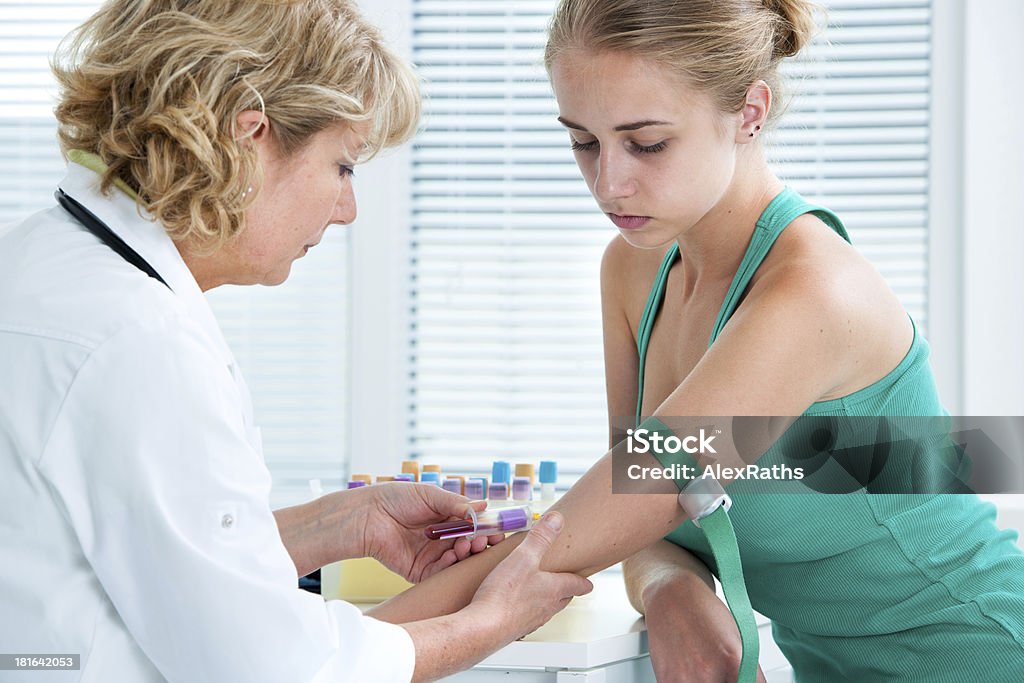 Nurse taking blood sample Nurse taking blood sample from patient at the doctors office. Blood Stock Photo