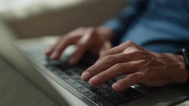 Senior man typing on laptop.