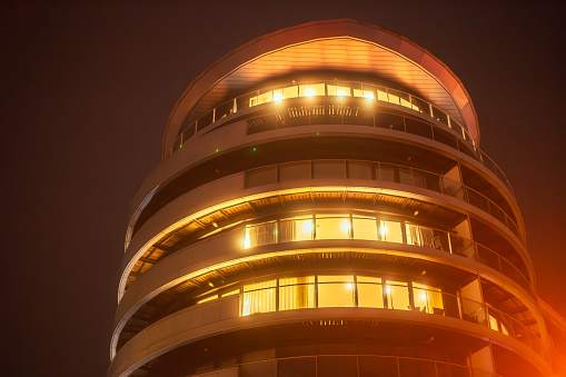 Exterior architecture of a futuristic apartment building illuminated at night in central London, UK.