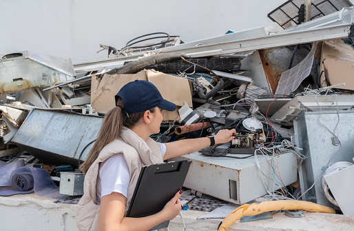 Recycle Engineer Working In Junk Pile Of Used Electronics