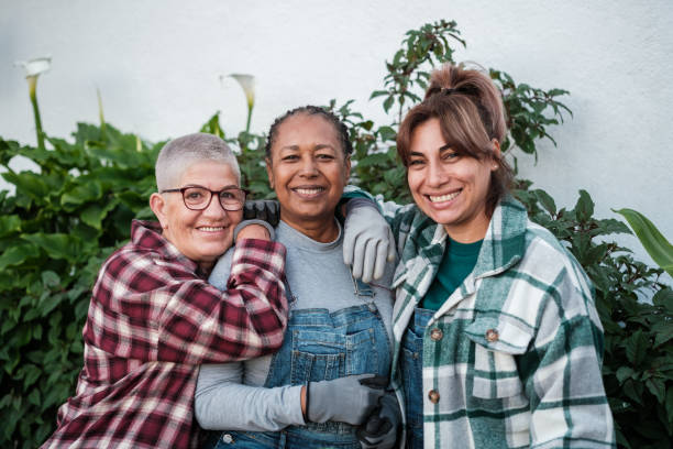 istock Three middle-aged friends smiling while gardening and having fun together. Concept: botany, hobby, fun 1816450312