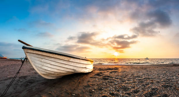 istock The boat rests on the sand when the sun sets 1816453531