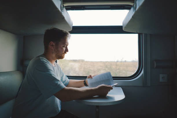 istock A man reading a book while traveling by Railway train 1816467186