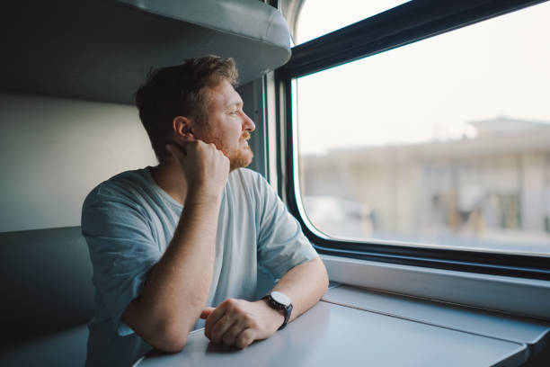 istock A man with a beard and mustache in a blue t-shirt while traveling by Railway train 1816468277