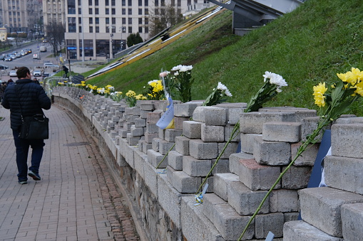 Kyiv, Ukraine - November 21, 2023: A woman alone in front of the Maïdan Memorial on the 10th anniversary.