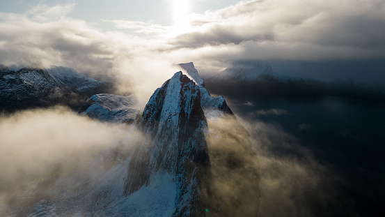 Aerial drone photo of snowy mountain hike up Segla in Senja, Norway.  Snowcapped mountains in the Arctic Circle of Northern Norway.  Famous hike on Senja island.  Shot in October on a DJI Air 2s.