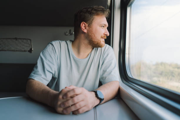 istock A man with a beard and mustache in a blue t-shirt while traveling by Railway train 1816474968