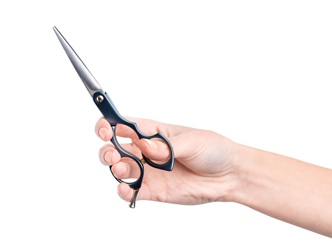 A woman's hand holds scissors for cutting hair. The hairdresser