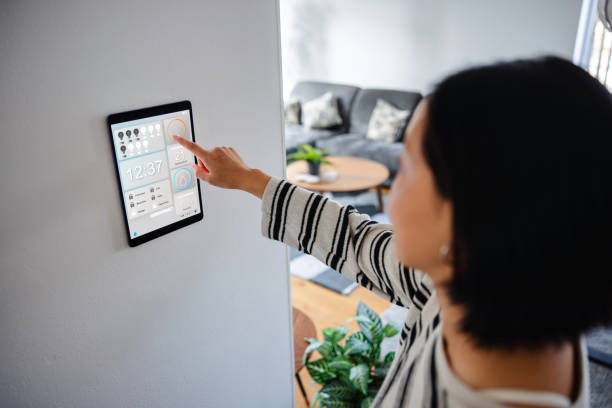 istock Asian Woman Interacting with Smart Home Control Panel 1816482115