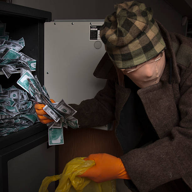 istock thief steals money from the safe 181648487