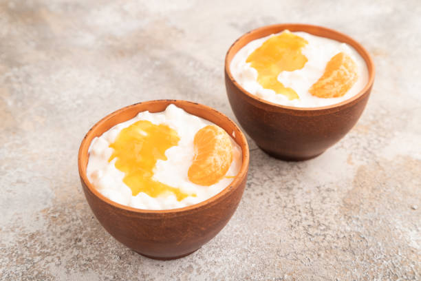 istock Grained cottage cheese with tangerine jam on brown concrete, side view. 1816491411