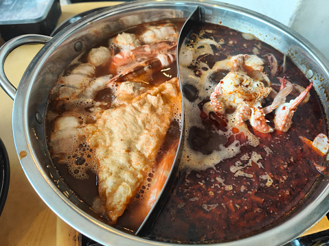 Steamboat pot with various protein such as crab, meatballs, beancurd slice in clear and mala soup broth