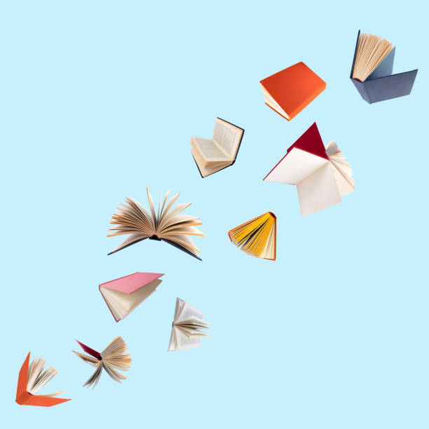 istock Colorful hardcover books flying isolated on blue background. 1816497952