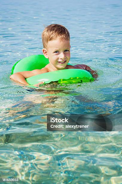 Glückliche Junge Die Schwimmen Im Meer Mit Gummiring Stockfoto und mehr Bilder von Aktivitäten und Sport