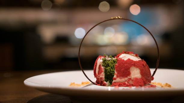 Red velvet cake filled with green matcha decorated with chocolate ring on white plate.