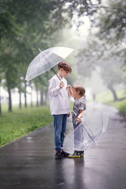 istock brothers with umbrellas 1816506783