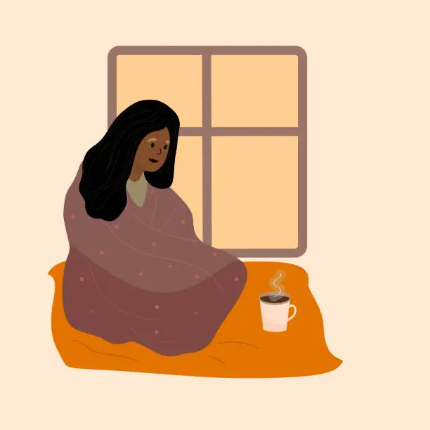 Vector illustration of Black Woman wrapped in cozy blanket is sitting next to teacup. Warm blanket Vector illustration. Afro-American is lonely sad. Cold evening at home.