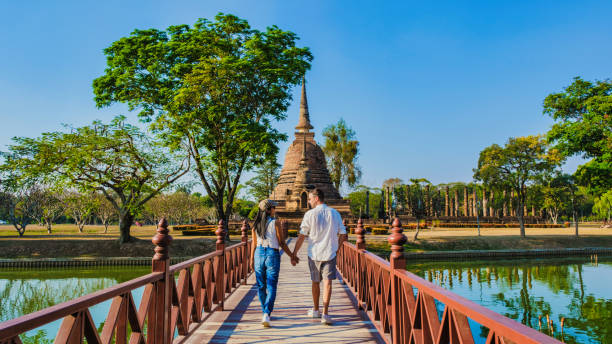 ein paar männer und frauen besuchen wat sa si, sukhothai altstadt, thailand., sukothai historischen park - thailand asia famous place stone stock-fotos und bilder