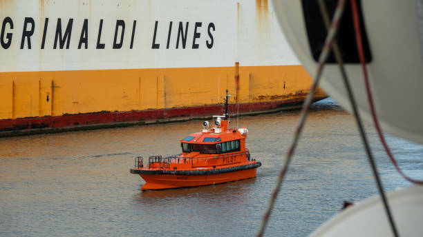 un petit bateau-pilote navigue entre deux grands navires - piloting commercial dock harbor industrial ship photos et images de collection