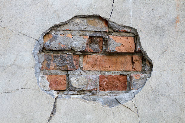 istock Hole in a wall red bricks looking out detail 181654783