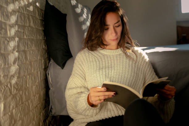istock Young mexican woman at home reading 1816563030