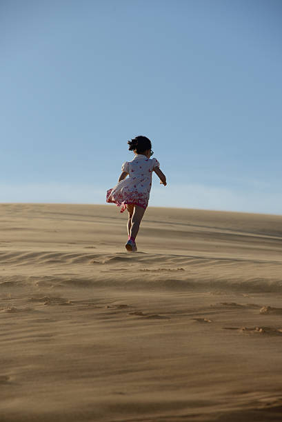 istock Young girl walking in the desert 181657415