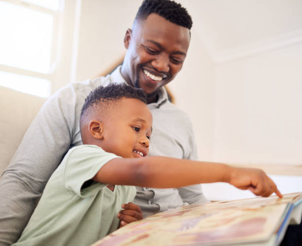 istock African, father and child in home reading book on sofa with development of language, education and learning. Happy dad, teaching and show kid a storytelling in books and relax in living room on couch 1816579086