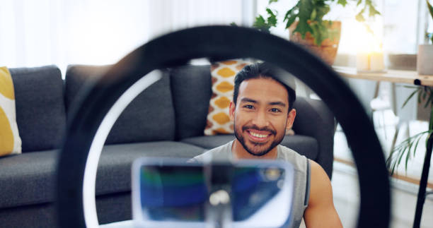 istock Fitness influencer man, live stream and home with smile, tutorial and training video on social media app. Asian personal trainer, recording and web blog for workout, exercise and wellness with advice 1816595327