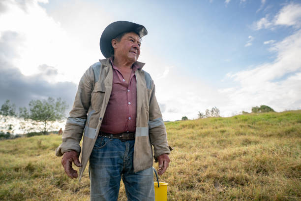 Latin American senior man working at his farm and looking away - agriculture concepts