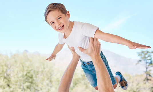 Child, portrait and parent flying in nature for fun and bonding together with happiness. Garden, airplane and father lifting his kid son for playful game in summer for carefree freedom and love