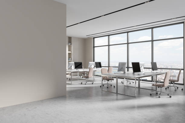 istock Modern workplace interior with pc monitors and armchairs, window. Mock up wall 1816619887