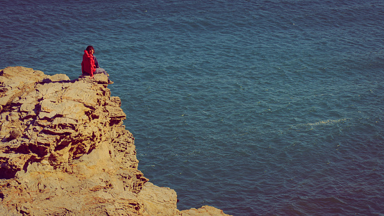 Tourist woman on spanish rocky coastline in Murcia region. Mediterranean Sea coast landscape, Calblanque Regional Park.