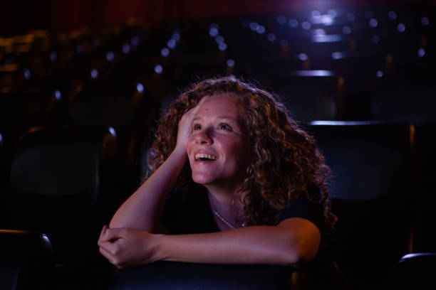 istock Young woman having a good time while watching a movie inside an empty theater 1816633979