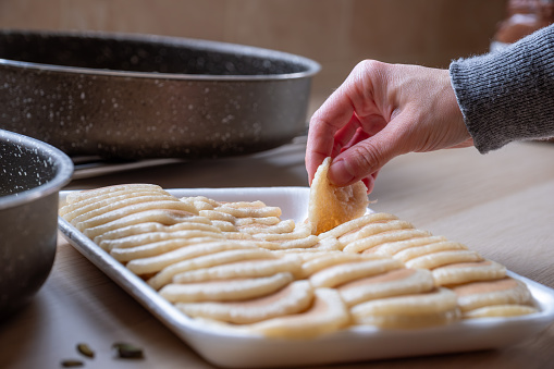 hands holding Qatayef ready to be filled and stuffed on wooden table