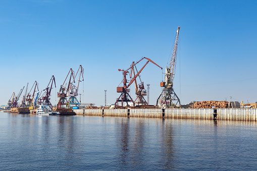 Harbor cranes in the river port on the pier.