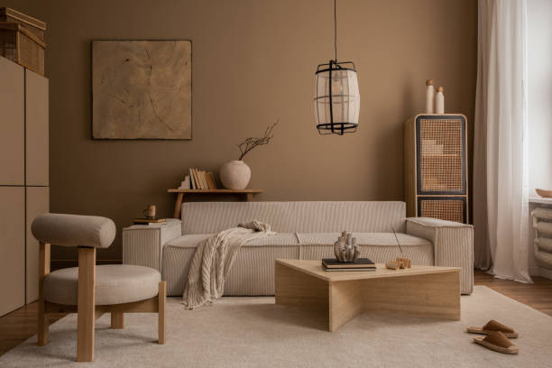 istock Elegant composition of warm living room interior with mock up poster frame, modular sofa, travertine coffee table, gray armchair, rattan sideboard, lamp and personal accessories. Home decor. Template. 1816652023