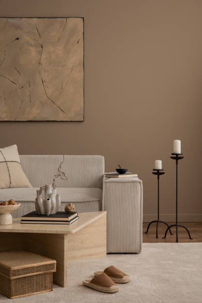 istock Minimalist composition of living room interior with mock up poster frame, beige sofa, travertine coffee table, braided basket, black candlestick and personal accessories. Home decor. Template. 1816652024