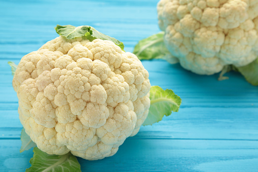 Fresh organic cauliflower on blue wooden background. Flat lay. Top view