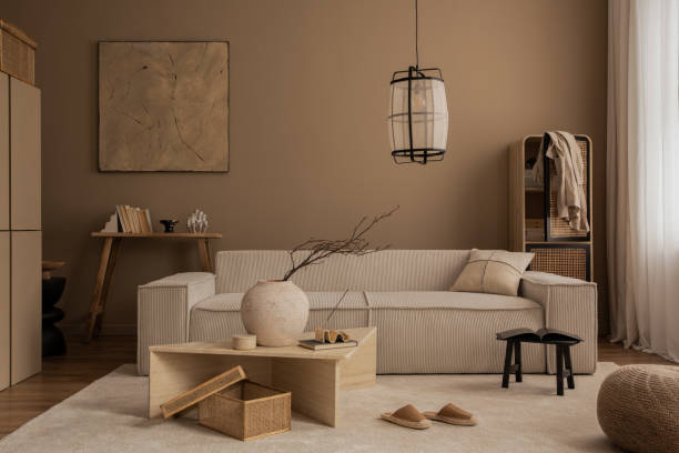 istock Elegant composition of warm living room interior with mock up poster frame, modular sofa, travertine coffee table, gray armchair, rattan sideboard, lamp and personal accessories. Home decor. Template. 1816652629